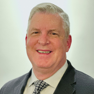 A formal photograph featuring a professional attire and neutral background.