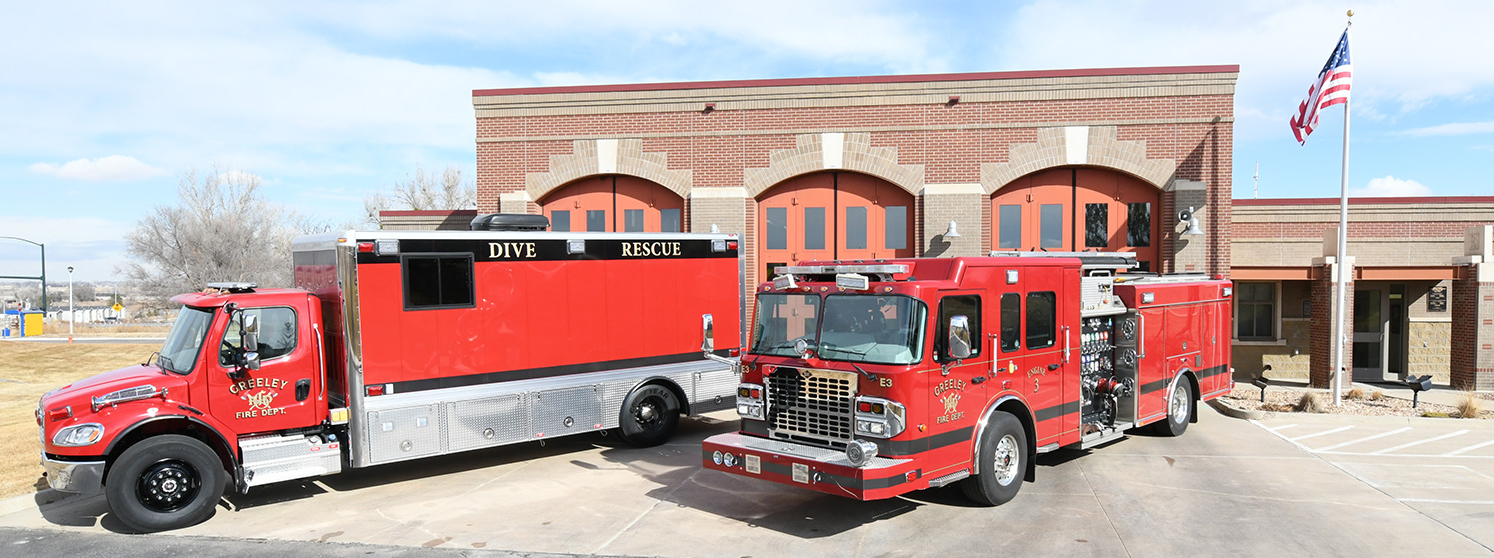 Front view of Greeley Fire Station 3 with fire trucks including a dive rescue vehicle parked outside.