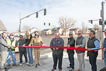 A group of city leaders and community members participating in a ribbon-cutting ceremony at a new public infrastructure site.
