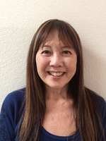 Image of an adult woman with long straight brown hair against a textured white background.
