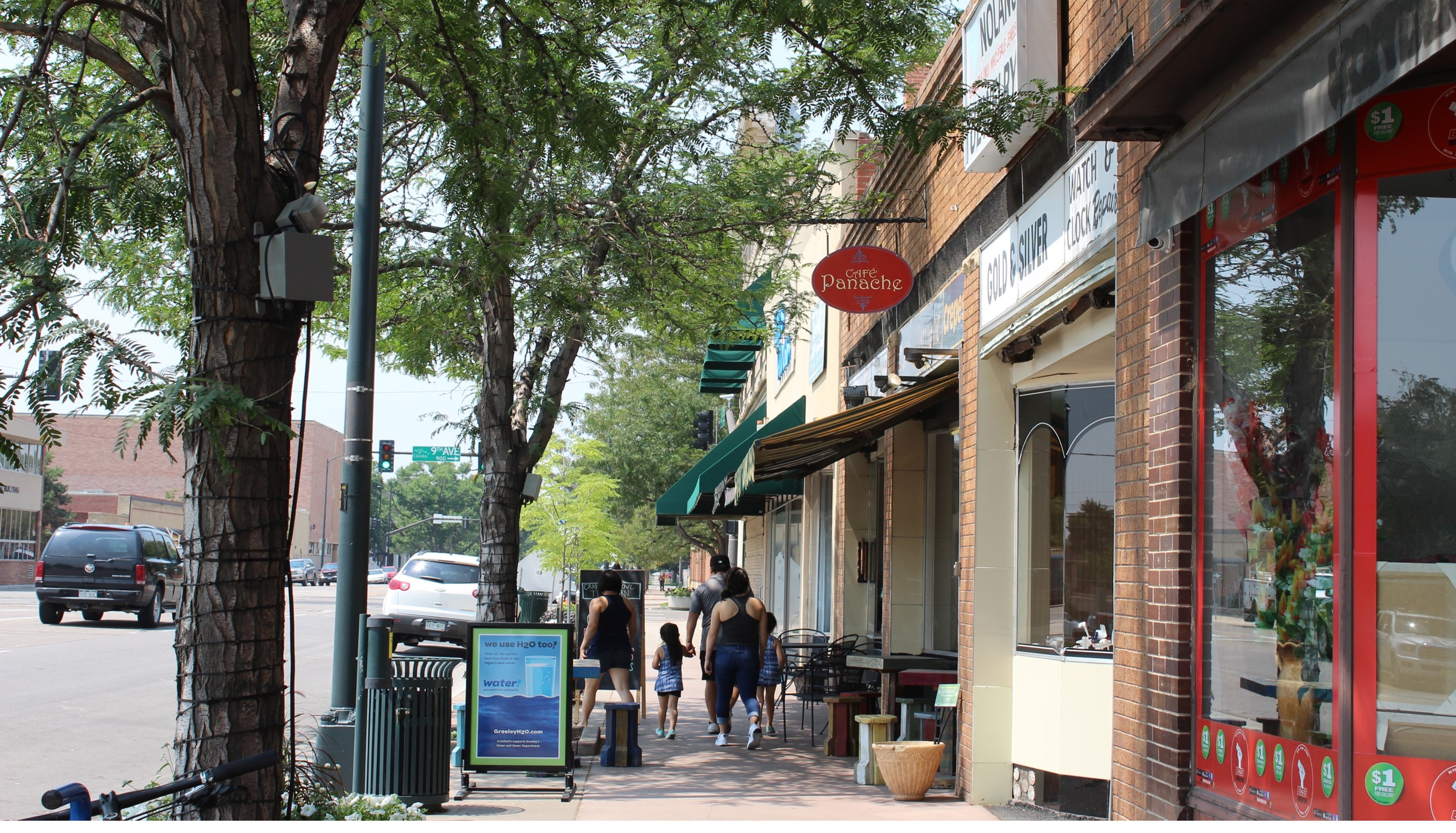 A vibrant shot of downtown Greeley featuring local shops, bustling sidewalks, and tree-lined streets.