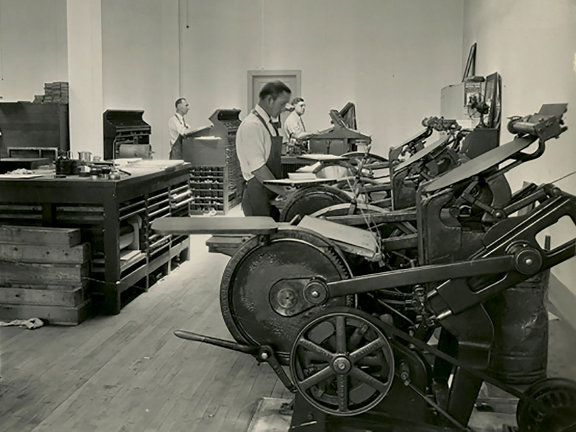 Greeley Tribune employees stand in front of printing presses
