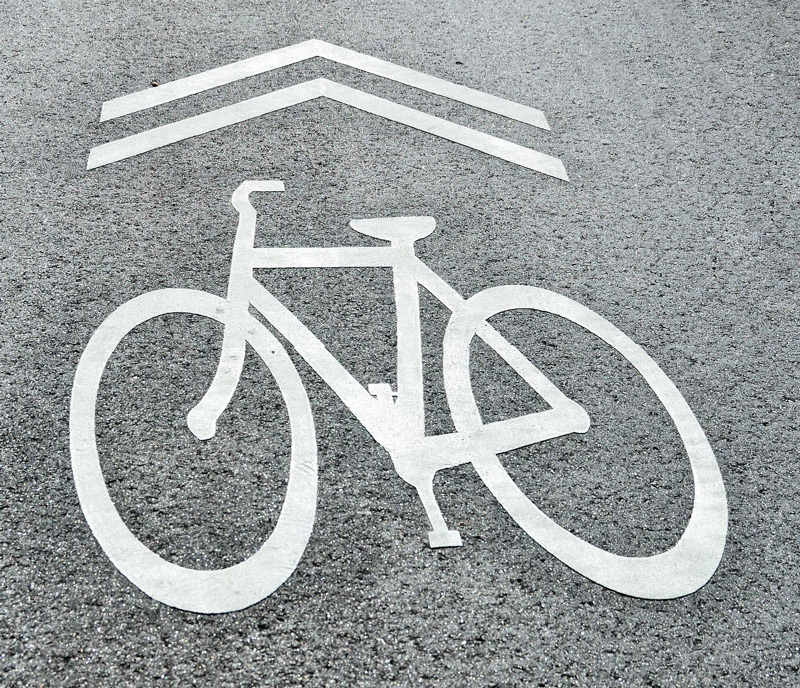 A clear bicycle lane marking painted on asphalt to designate safe cycling areas.