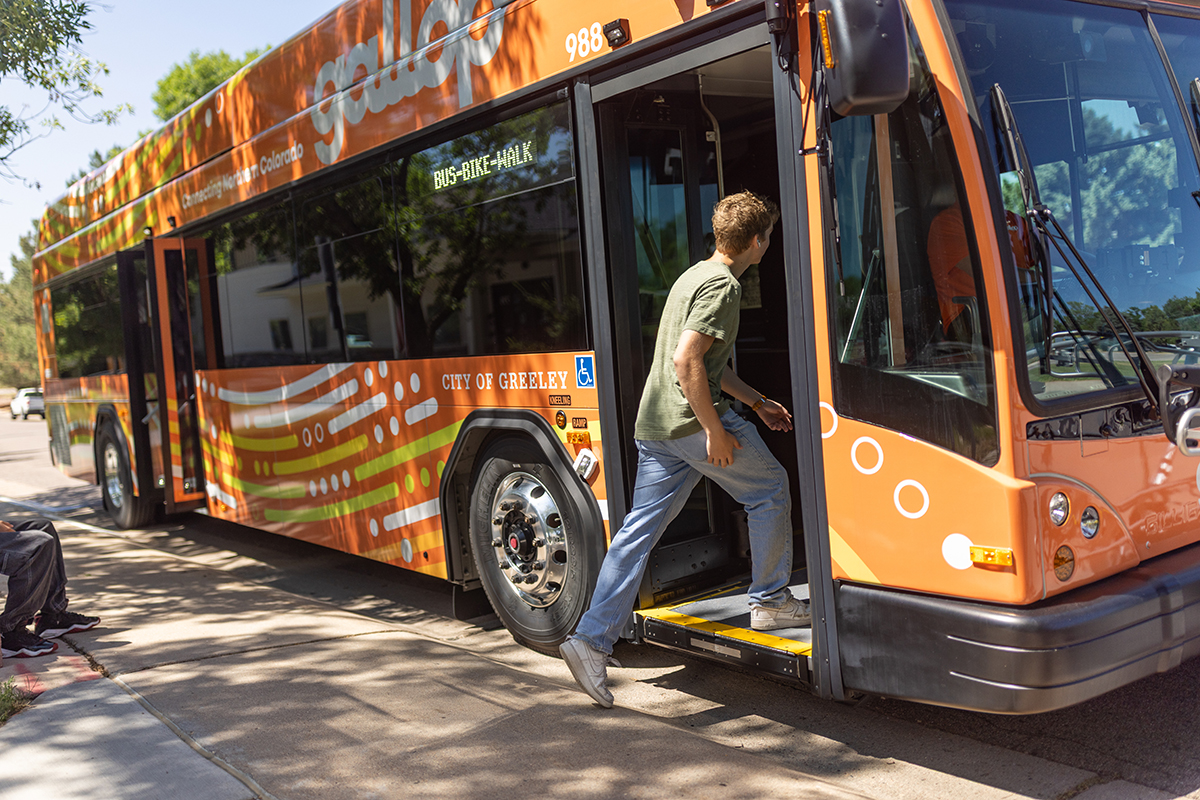 young man stepping onto gallop bus