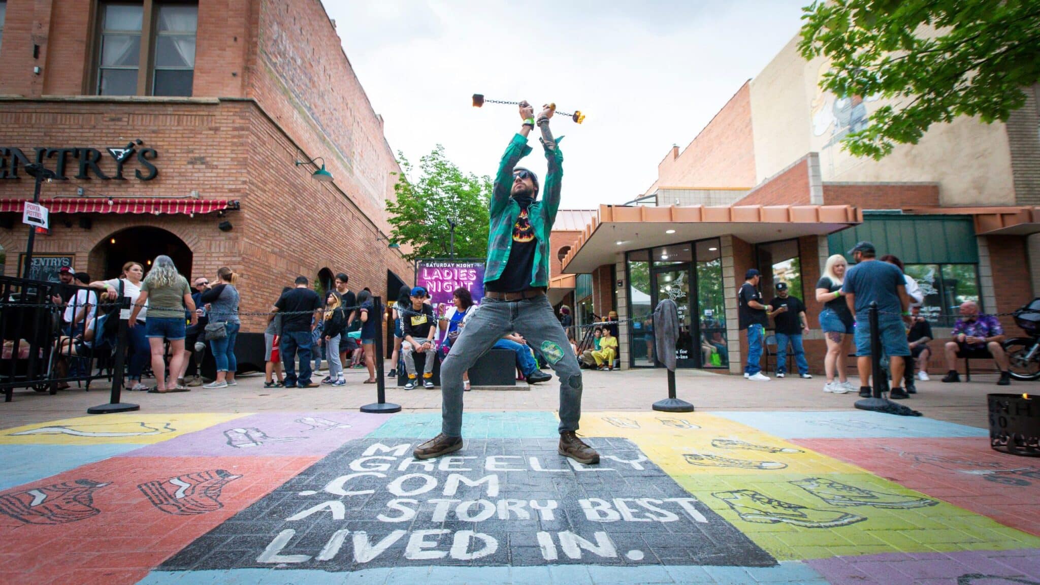 A lively street gathering featuring performances and activities near local businesses.