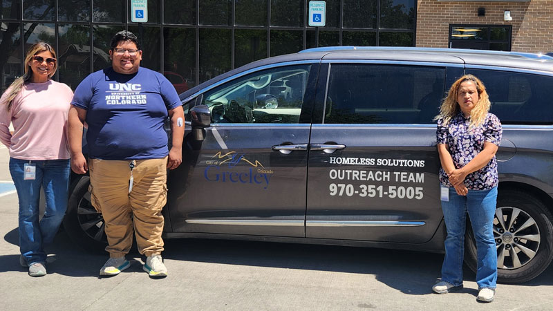 Members of Greeley's Homeless Solutions Outreach Team standing beside their outreach van.