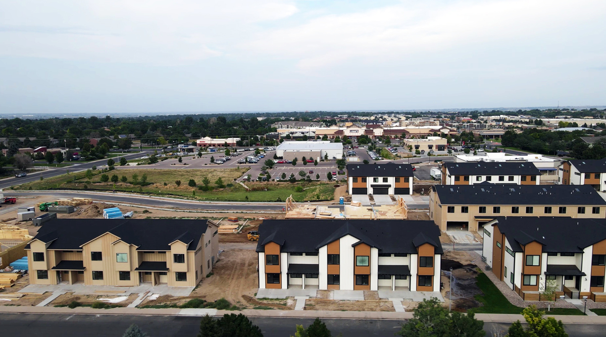 Aeriel view of a series of multi-level townhomes in various stages of development.