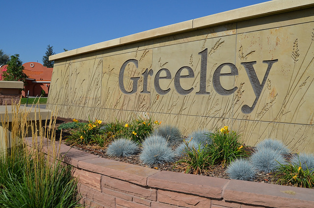 A beautifully landscaped Greeley sign with decorative plants and a clean architectural design.