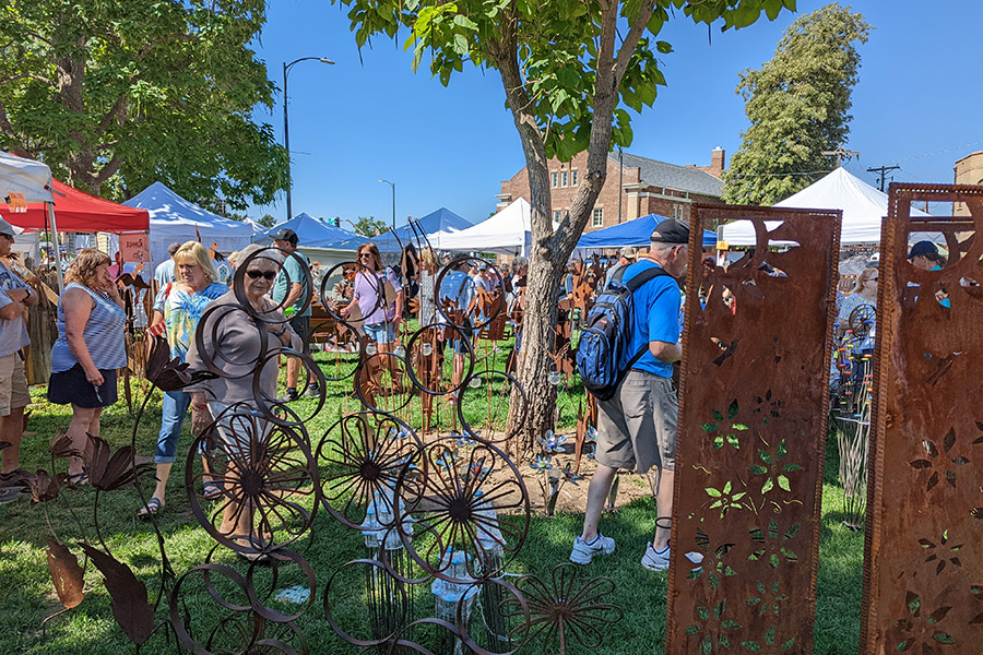 A view of patrons exploring handcrafted art displays at the Greeley Arts Picnic.