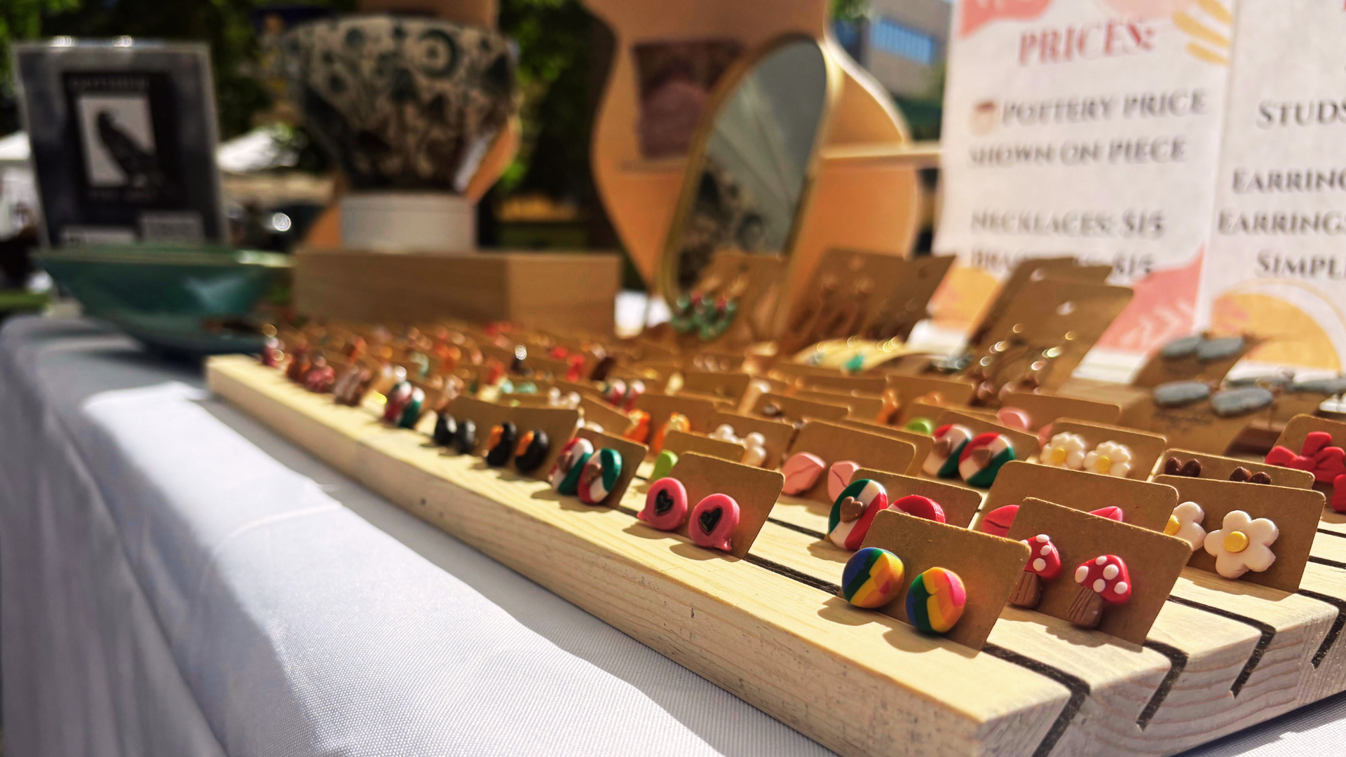 Close up of handmade stud earring display in wood container at the Greeley Arts Picnic