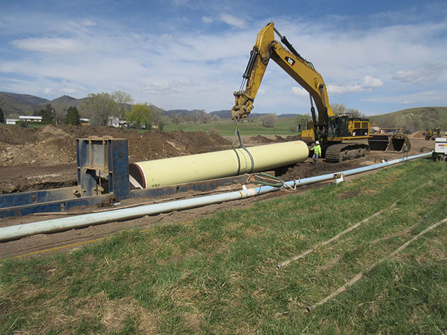Heavy equipment lowers pipeline into place