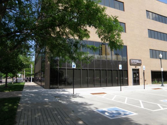 A view of the City of Greeley administration building showcasing its modern architecture and nearby parking spaces.