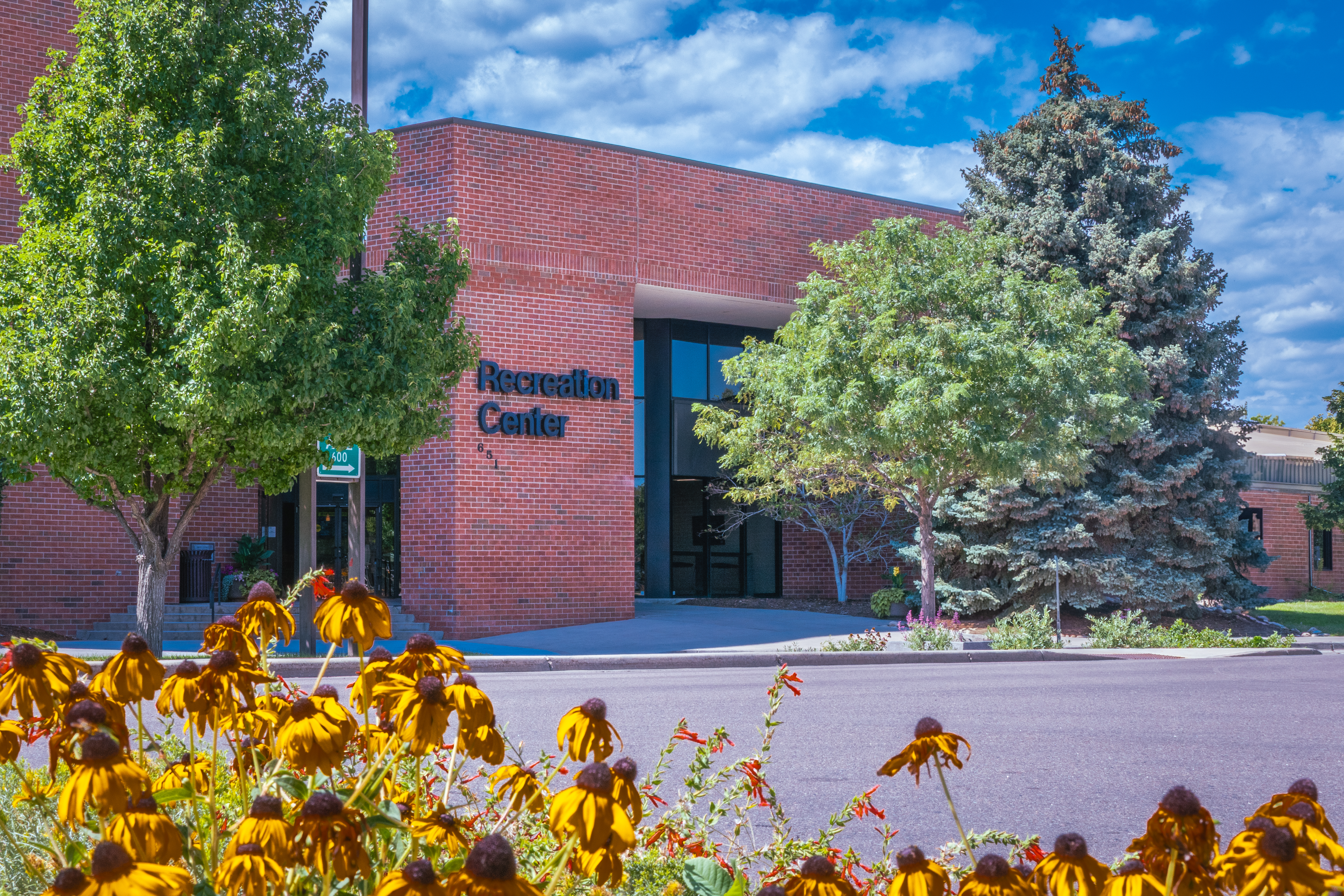 A photograph of the Greeley Recreation Center during summer from across 10th Avenue.