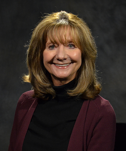 Portrait of Cheri Witt-Brown showcasing professional attire against a neutral background.