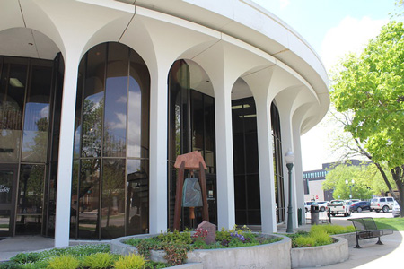 A view of the modern architectural design of the City Hall building with surrounding greenery and public amenities.