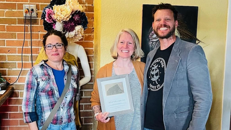 Christen DePetro honors Kelly and Jeff Cook for their efforts in rehabilitating the Ambry with an award.