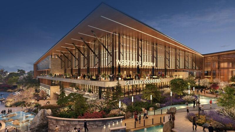 Artist's rendering of the proposed Colorado Eagle's hockey arena to be built in West Greeley.  The building is modern and sleek, with large expanses of glass, metal, and a slanted flat roof.  Large, lit letters on the front of the building read "WEST SIDE ARENA" and "GREELEY, COLORADO".  Raised stone flowerbeds are filled with colorful bushes and shrubbery and a small pond with fountain are off to the left of the building.  A walkway lined with lights and black metal railing allows pedestrians to cross a lazy river that winds around the right side of the building.  The scene is at dusk, with lit street lights lining the walkways.