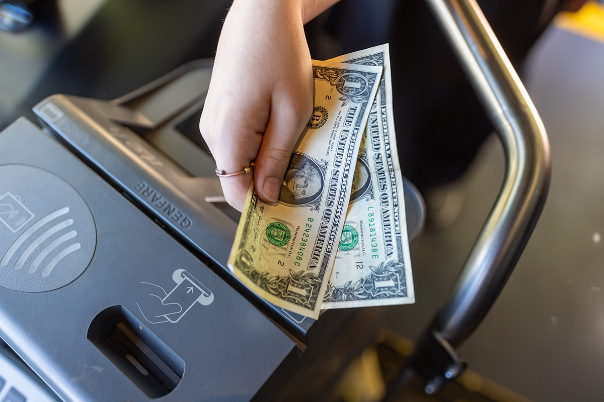 Person's hand holding dollar bills