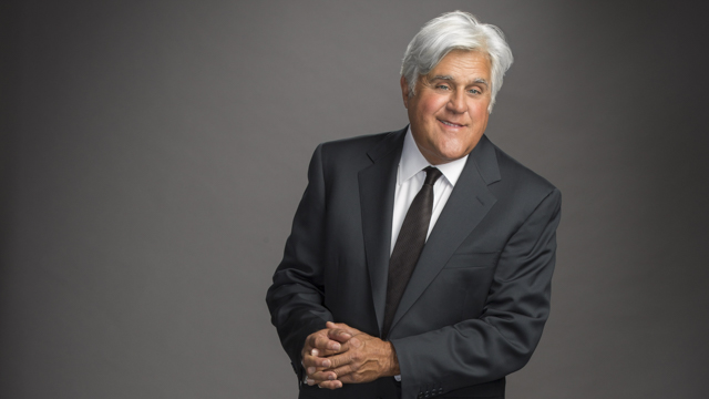 Jay Leno poses wearing suit.