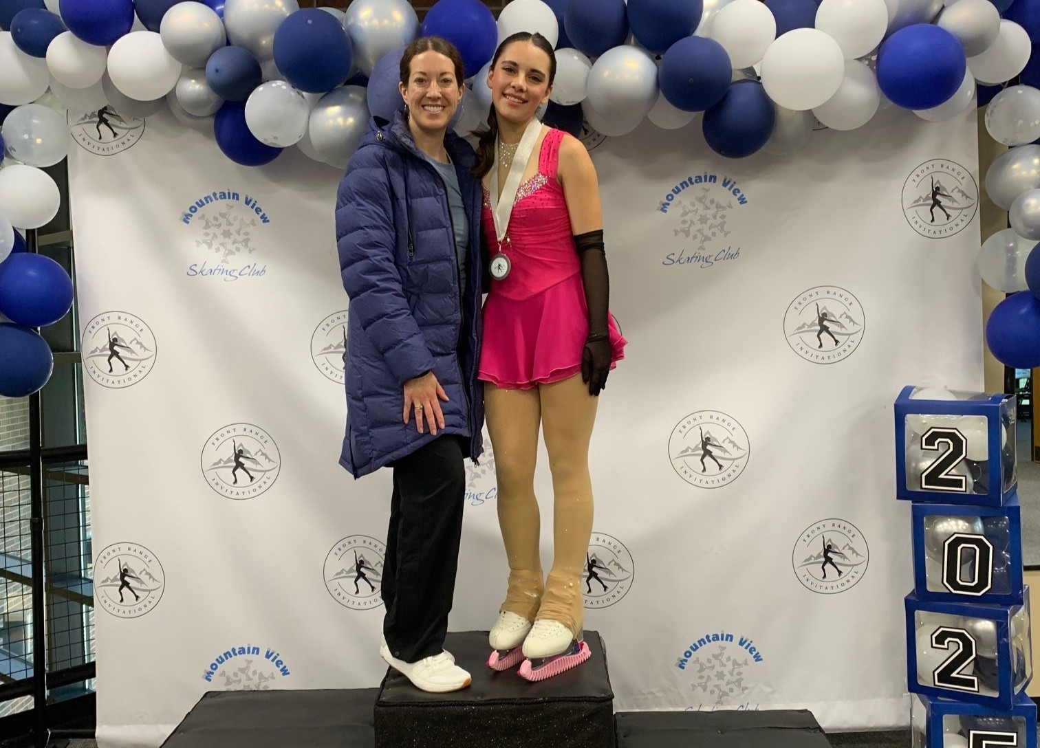 Greeley skater Haley Madsen poses with her coach Sarah Bott at the US Figure Skating 2025 Excel Series National Final and Festival on a podium