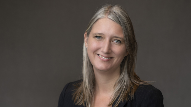 A professional portrait of Mandy Shreve with a plain background, showcasing a formal appearance.