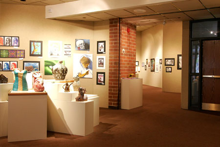 An art gallery showcasing diverse art pieces with sculptures and framed artwork.