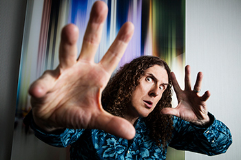 An individual reaches toward the camera, surrounded by vibrant and abstract background elements.