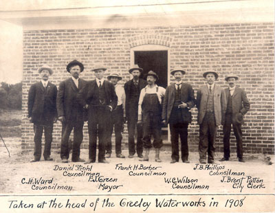 A historic photo of Greeley city officials, including the mayor and councilmen, posed in front of the waterworks building in 1908.