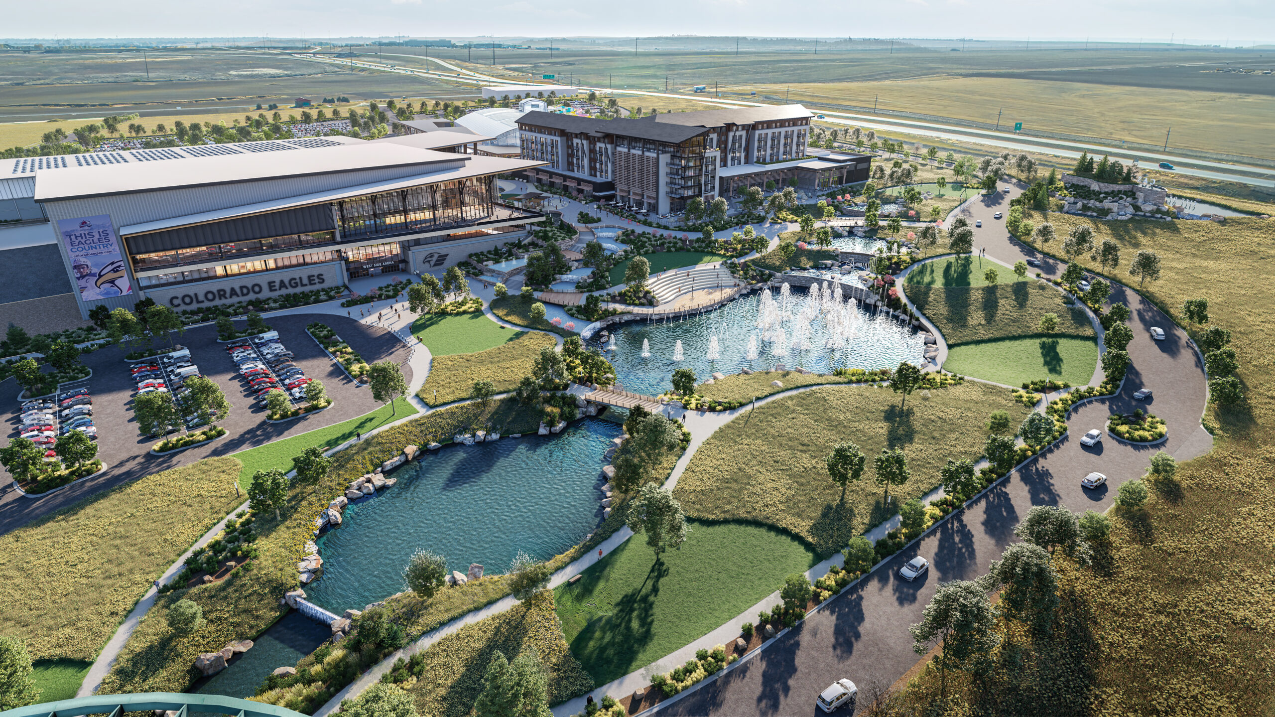 This image depicts an artist's rendering of the proposed Cascadia Project in West Greeley.  The image shows an aerial view of the planned Colorado Eagles hockey arena, as well as a multi-story waterpark hotel.  The modern buildings contain large expanses of glass windows, leading to outdoor space.  Two large lakes in front of the buildings are surrounded by grass and lush trees, and fountains inside on lake create water jets into the air.  