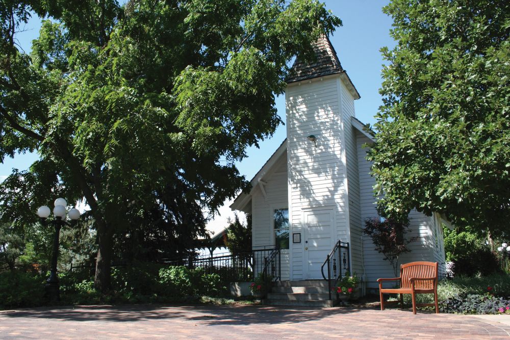 White clapboard church surrounded by trees.