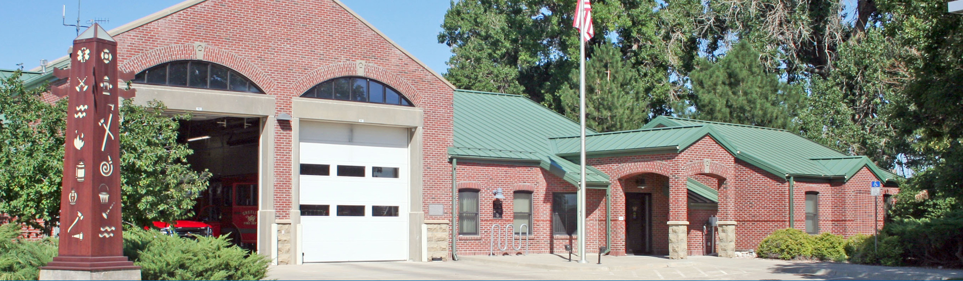 A well-maintained brick fire station with green roofing, showcasing its historic design and functionality.