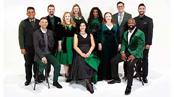 A formal group photo of Voctave, showcasing members dressed in elegant green and black attire.