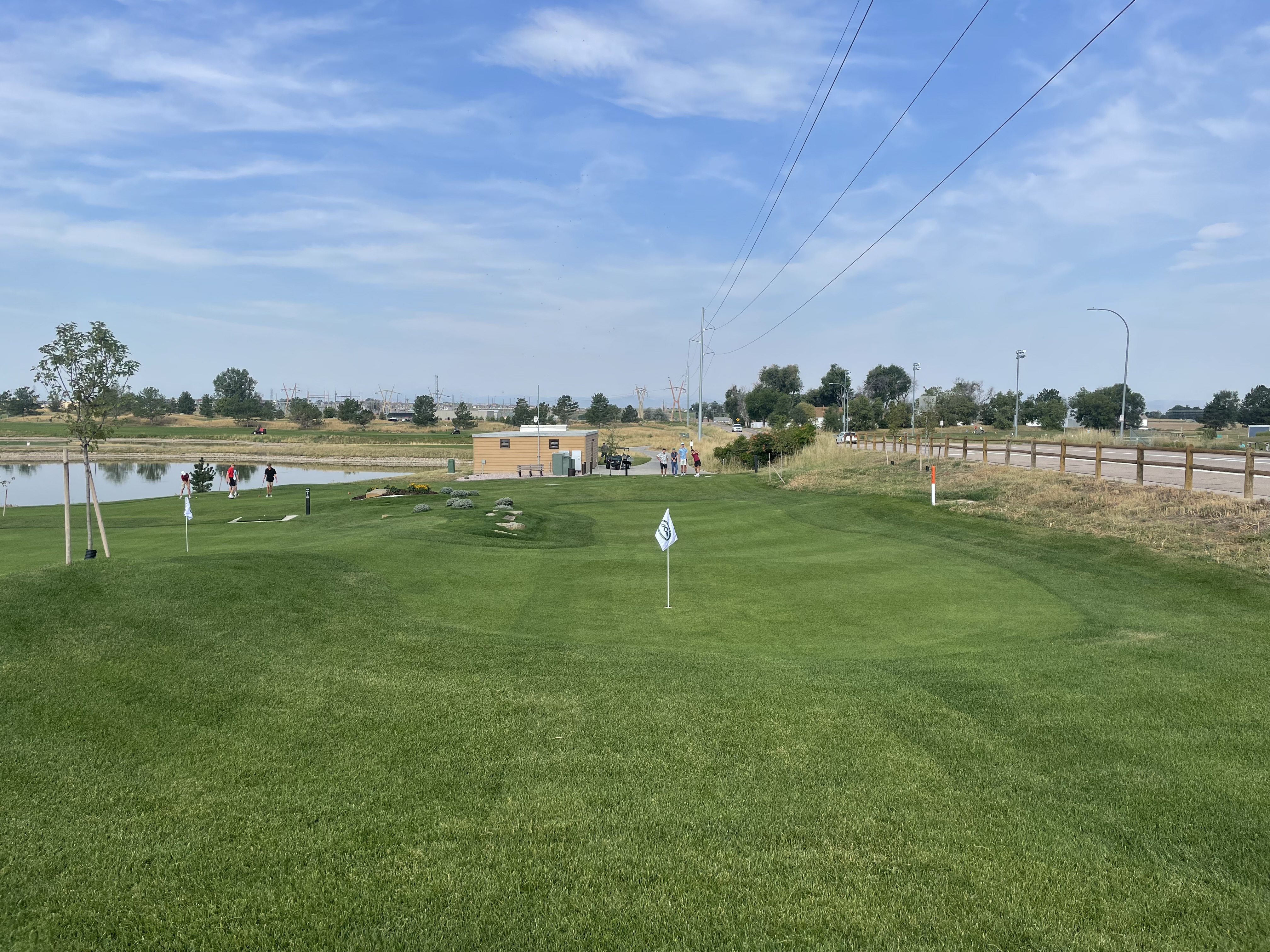 Golfers teeing off on the short course at Boomerang Links with manicured grass and open landscape in the background
