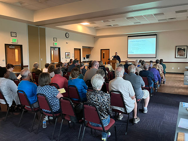 Buxton Demers from the City of Greeley Code Compliance presenting to an audience with a PowerPoint presentation