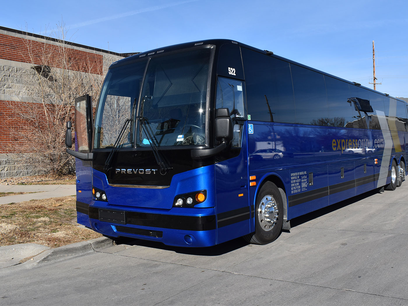 Express Arrow bus waiting at the curb of a brick building