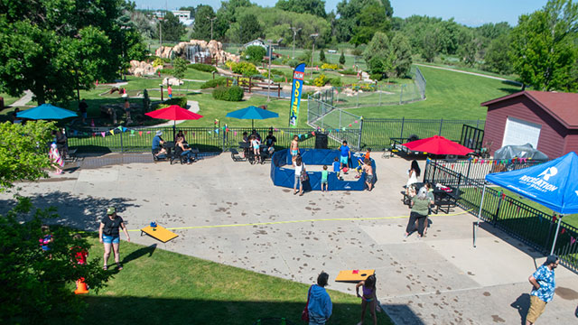Families play games outdoors on a summer day by the miniature golf course at the Family FunPlex