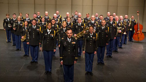 Group photo of the 101st Army Band of the Colorado National Guard in full uniform on a stage.