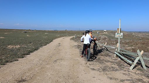 Cyclists pause at a scenic trail in Greeley's natural area, enjoying the expansive views and open spaces.
