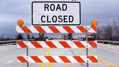A barricade signaling a road closed due to construction or maintenance, emphasizing public safety.