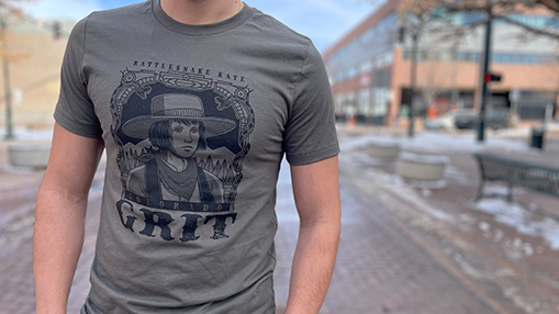 A person wearing a t-shirt with Western-inspired graphic design in an urban setting.