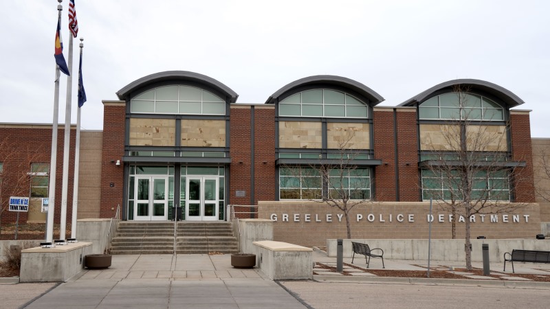 Front view of the Greeley Police Department building featuring a brick and stone facade, large windows, and a sign displaying its name.
