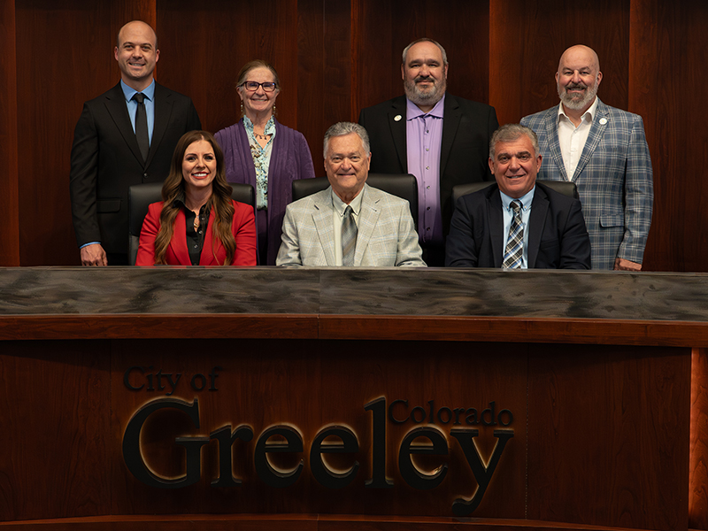 Greeley City Council behind the dais. In the back row stands Craig Huddleston, Deb DeBoutez, Brian Rudy, and Ryan Roth. In the front row sits Melissa McDonald, Dale Hall, and Johnny Olson.


