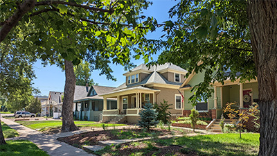 A picturesque view of Cranford neighborhood, showcasing charming homes surrounded by greenery on a sunny day.