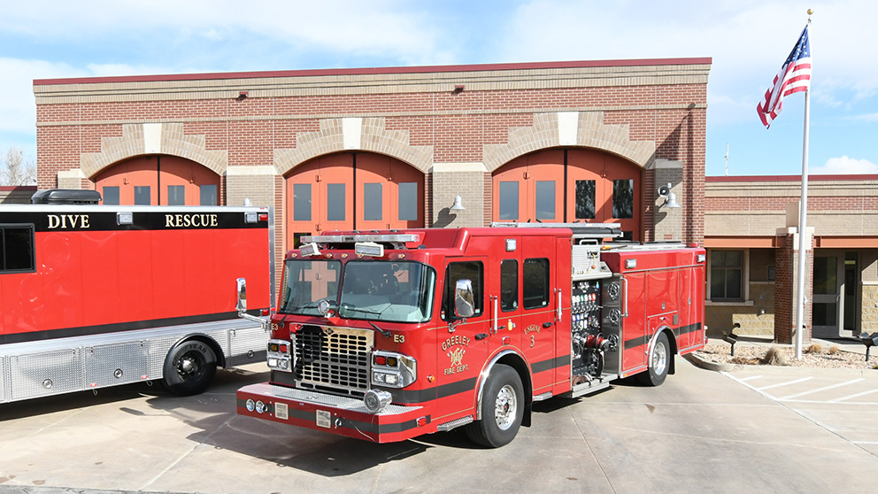 Front view of Greeley Fire Station 3 with fire trucks including a dive rescue vehicle parked outside.

