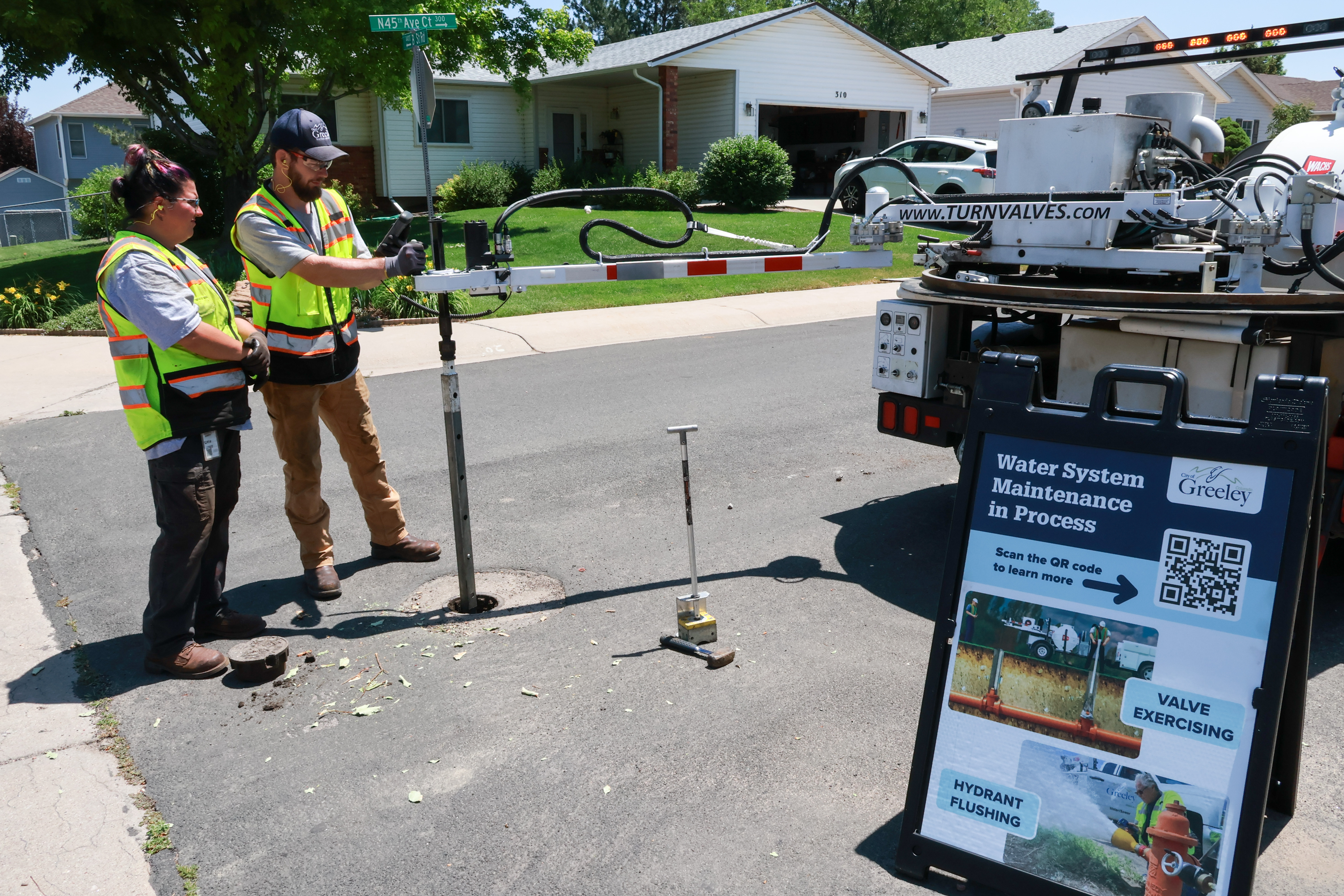 Certified operators using specialized equipment to exercise a valve. 