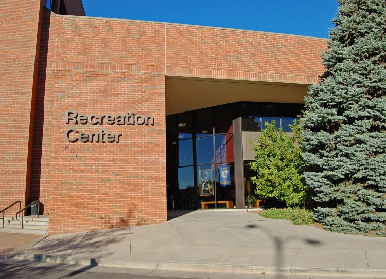 Exterior view of the Greeley Recreation Center showcasing its brick facade and entrance surrounded by greenery.