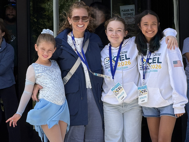 Coach Ludy poses with three Ice Haus figure skaters at a National competition in Massachusetts