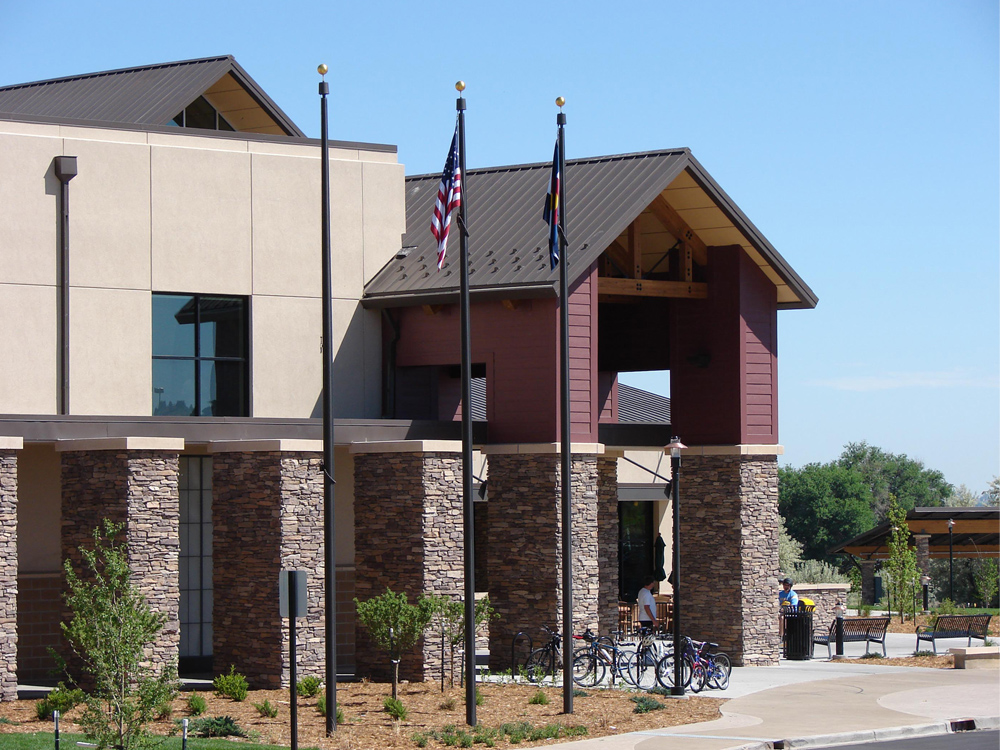 Exterior view of Family Funplex showcasing stone pillars, flags, and recreational facilities surrounded by landscaping.