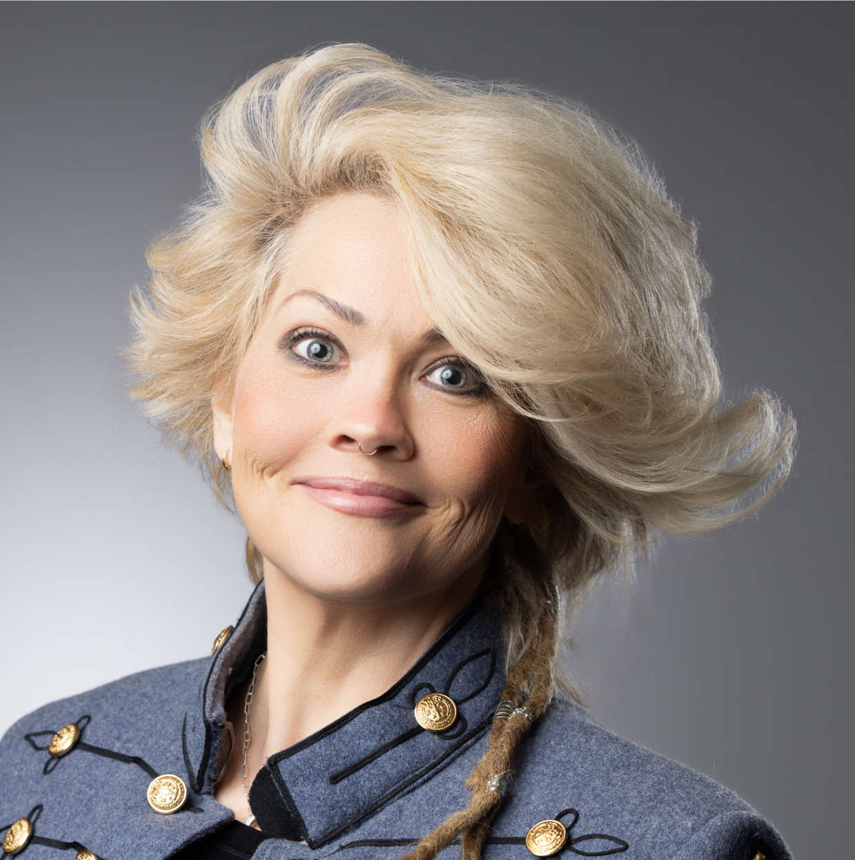 This image depicts a professional headshot of Economic Development Administrative Coordinator Erin Dawson.  Erin is shown in gray jacket with bronze buttons.  