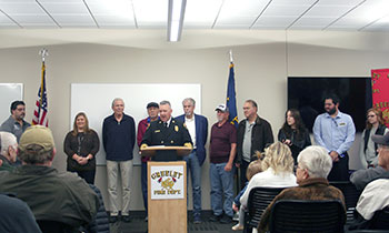 A public meeting showcasing local leaders addressing community safety and collaboration efforts.